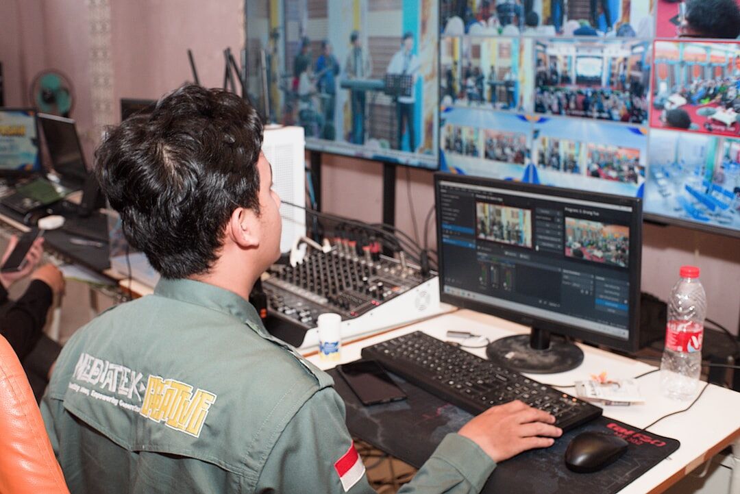 TV broadcasting control room with multiple monitors and equipment